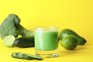 Glass of fresh vegetable juice on color background