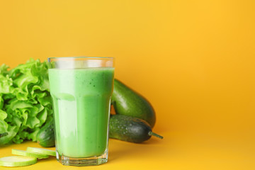 Glass of fresh vegetable juice on color background