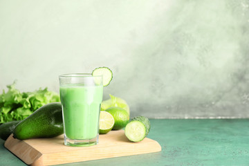Glass of fresh vegetable juice on color background