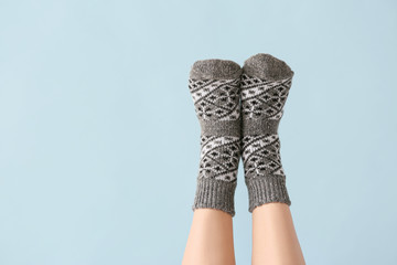 Legs of young woman in socks on color background