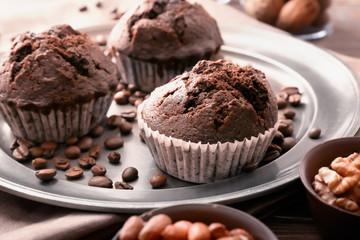 Plate with tasty chocolate muffins on table