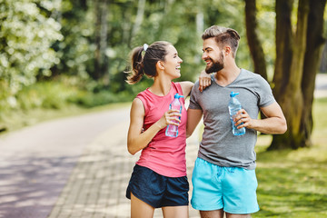 Happy couple resting after running at park