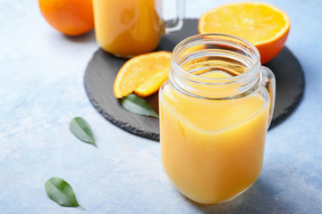 Mason jar of fresh orange juice on table