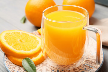 Glass cup of fresh orange juice on table
