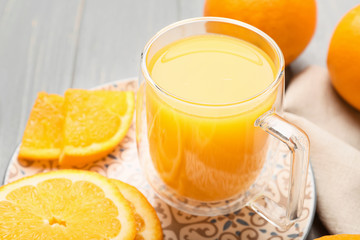 Glass cup of fresh orange juice on table
