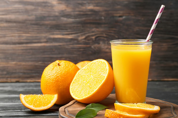Glass of fresh orange juice on table