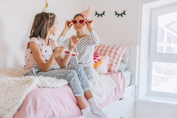 Kids paljamas party in white bedroom interior