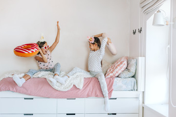 Kids paljamas party in white bedroom interior - 322006501