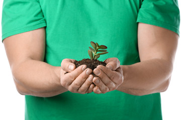 Man with plant and soil on white background, closeup. Earth day celebration