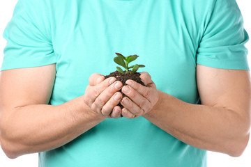 Man with plant and soil on white background, closeup. Earth day celebration