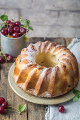 Fresh homemade bundt cake with cherry on wooden table