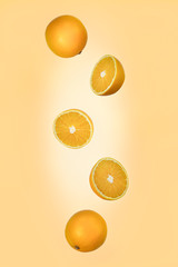 Falling orange isolated on a light orange background with clipping path as package design element and advertising.