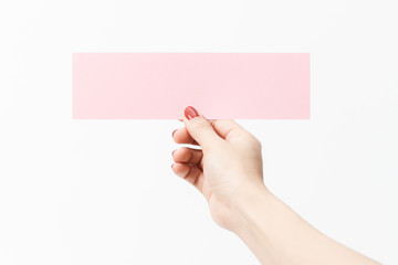 Obraz premium Close up women holding pink blank paper on white background.