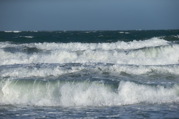 Sea waves against cloudy sky