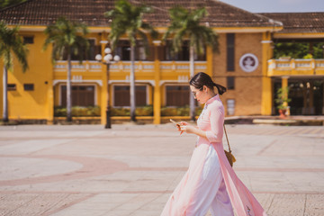 Asian woman walking on street at Hoi An Ancient town.