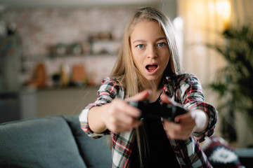 Girl playing video games at home. 