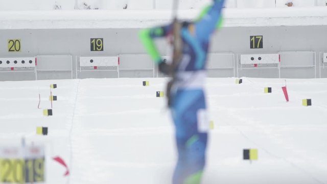 Footage of a biathlon contestant shooting in standing position to the target