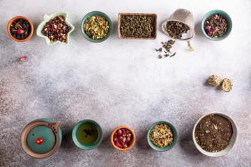 Assortment of dried tea in ceramic bowls. Black, green and herbal tea collections. Top view, copy space. Food background.