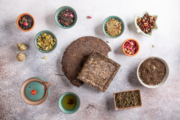 Assortment of dried tea in ceramic bowls. Black, green and herbal tea collections. Top view. Food background.
