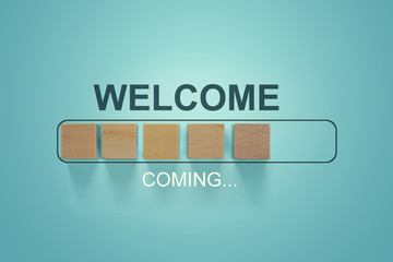 The word WELCOME with wooden blocks in loading bar progress.