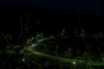 Una carretera por la noche con casa al rededor.