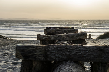 Unos troncos de madera que dirigen al mar.