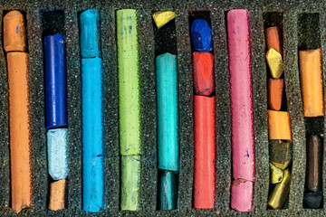 Extreme close-up of used pastel sticks in a box