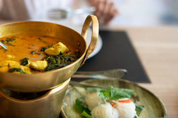 Crab curry with betel leaves in a brass pan at restaurant.