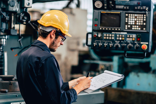 Young Profession Technician Engineer Operate Heavy Machine To Automated CNC In Factory, Worker With Check List.