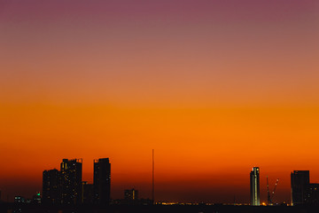 Fototapeta na wymiar Silhouette dusk city quiet calm sunset sky no cloud orange sky view space for text.