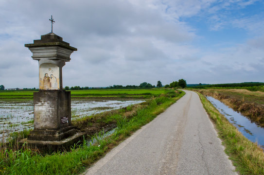 Un vecchio tabernacolo sul ciglio di una strada di campagna vicino a Vercelli lungo la Via Francigena