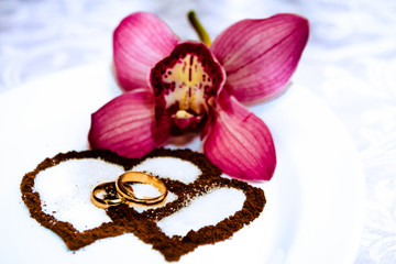 Wedding rings, tender orchids and coffee hearts
