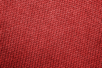 Fragment of bright red knitted clothes. Close-up. Top view