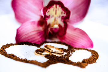 Wedding rings, tender orchids and coffee hearts