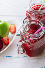 Detox smoothie from apple, beet, carrots, strawberry and spinach in mason jar on  old, wooden background. Ingredients for a detox smoothie.  High key. Selective focus.