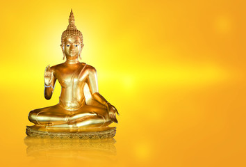 Golden Buddha statue with glittering aura on a golden yellow background for design and a beautiful background.