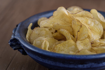 Kartoffelchips liegen in einer blauen Schale