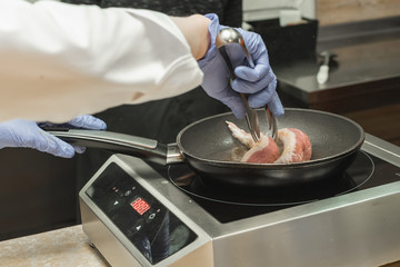 frying delicious juicy pork on the black frying pan