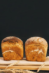 Fresh homemade bread with sunflower seeds, isolated on a wooden background. Side view, top view, close-up view. Ears of wheat, rye. Healthy diet. Carbohydrates. Cereals.