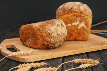 Fresh homemade bread with sunflower seeds, isolated on a wooden background. Side view, top view, close-up view. Ears of wheat, rye. Healthy diet. Carbohydrates. Cereals.