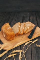 Fresh homemade bread with sunflower seeds, isolated on a wooden background. Side view, top view, close-up view. Ears of wheat, rye. Healthy diet. Carbohydrates. Cereals.