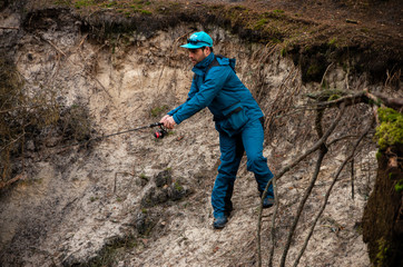 Naklejka premium Fisherman angler fishing forest river blue costume catch trout