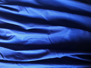 blue textile background close-up. Satin or silk fabric background close-up. Copy space