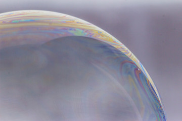 Macrophotography of a soap bubble. Multicolored streaks on the surface of the soap bubble