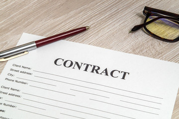 Contract form for filling with pen and glasses on table