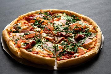 Pizza with Mozzarella cheese, mushrooms, ham, tomato sauce, sausage, pepper, Spices and Fresh arugula. Italian pizza