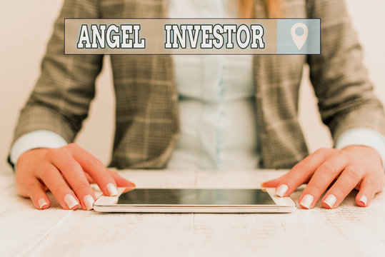 Text Sign Showing Angel Investor. Business Photo Showcasing High Net Worth Individual Who Provides Financial Backing Business Woman Sitting With Mobile Phone On The Table