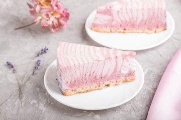 Homemade pink cheesecake with cup of coffee on a gray concrete background. side view, selective focus.