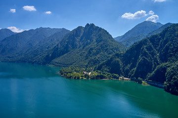 Fototapeta na wymiar Panoramic view of the mountains and Lake Idro. Reflection in the water of the mountains, trees, blue sky. Aerial view, drone photo