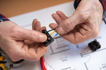 Fototapeta premium Electrician connecting wires in terminal block